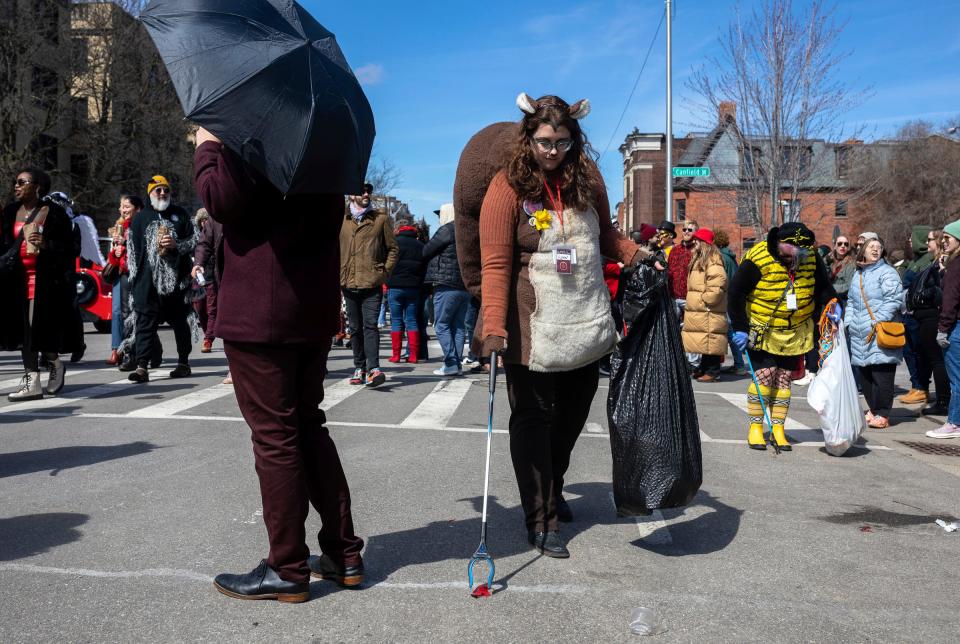 Lynn Blasey, 40, program manager of the Community Arts Partnerships office at the College for Creative Studies, picks up trash dressed as a squirrel during the Marche du Nain Rouge 2024 parade in Detroit on Sunday, March 24, 2024.