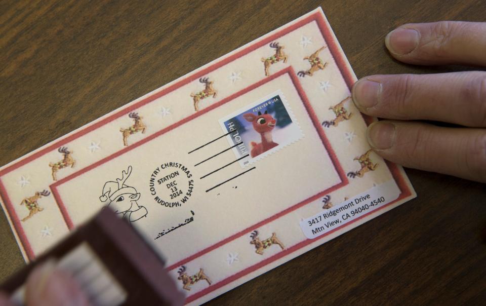 The postmaster in Rudolph, Wis., postmarks a card sent from California with a special Country Christmas postmark in 2014.