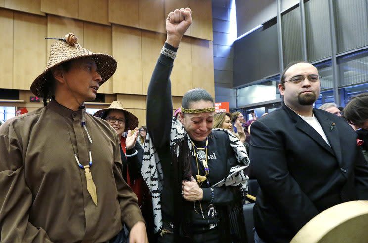 Olivia One Feather, center, of the Standing Rock Sioux tribe, in Seattle on Feb. 7, salutes its City Council’s vote to divest from Wells Fargo for lending to the Dakota Access pipeline project and for other business practices. Wells Fargo manages more than $3 billion of Seattle’s operating account. (Elaine Thompson/AP Photo)