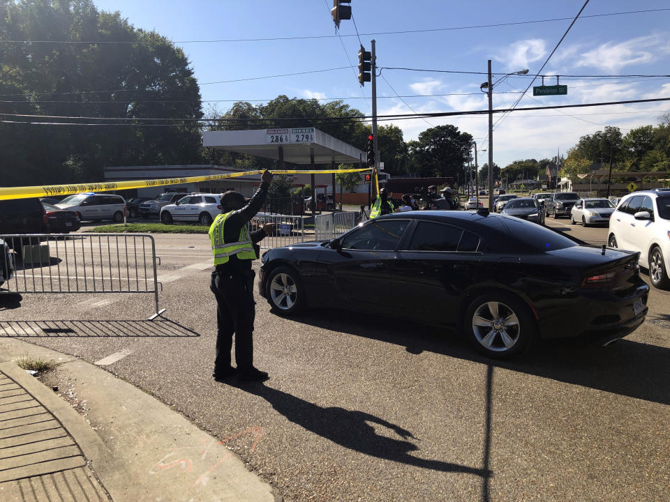 Officers allow a police vehicle to pass under yellow crime scene tape on a street in front of the post office in Memphis. Police said they are investigating a shooting at the post office in Tennessee. (AP Photo/Adrian Sainz)