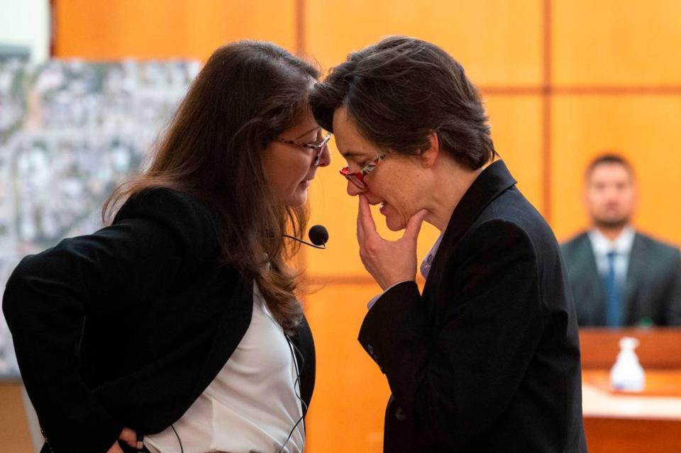 State assistant attorneys general Barbara Serrano (left) and Melanie Tratnik talk about a line of questioning while former Tacoma Police Department officer Corey Ventura sits on the witness stand on Thursday, Dec. 1, 2022, at Pierce County District Court in Tacoma.