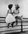 Two young women sit on a railing in Blackpool in 'Maidens in Waiting', 1951. This is one of Hardy's most recognisable images (Bert Hardy/ Getty Images)