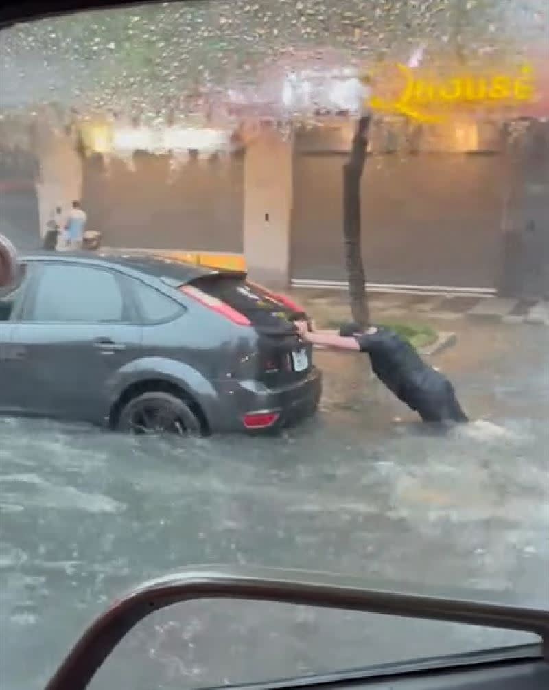 有車輛拋錨，駕駛在水中推車前行。（圖／翻攝畫面）