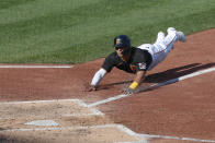 Pittsburgh Pirates' Phillip Evans, left, dives for home plate to score on a wild pitch by Detroit Tigers starter Ivan Nova to Pirates' Jacob Stallings in the fourth inning of a baseball game Saturday, Aug. 8, 2020, in Pittsburgh. (AP Photo/Keith Srakocic)