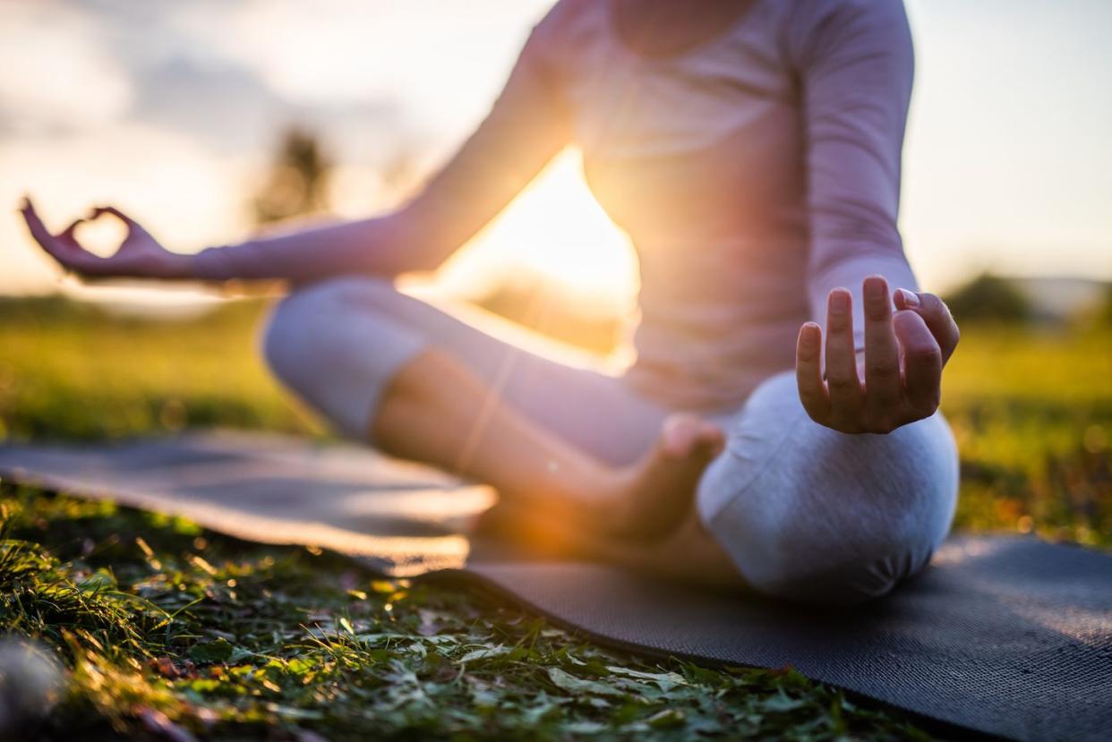 a person meditating at sunrise in a park