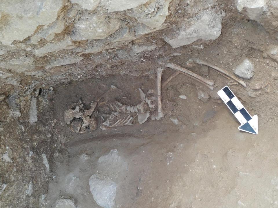 Remains of a ten year old child buried in a Roman cemetary in the 5th century with a stone in the mouth are shown here.