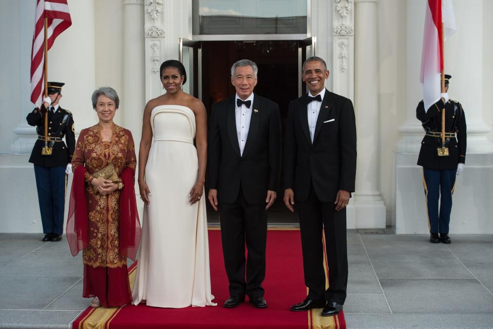 US President Barack Obama (R) and First Lady Michelle Obama (2nd L) greet Singapore's Prime Minister Lee Hsien Loong (2nd R) and his wife Ho Ching for a state dinner at the White House in Washington, DC, on August 2, 2016. / AFP / NICHOLAS KAMM (Photo credit should read NICHOLAS KAMM/AFP/Getty Images)