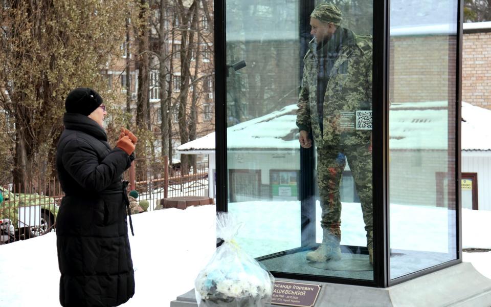 Mother Paraska Matsiievska-Demchuk stands by the monument depicting her son, who was executed by Russian forces