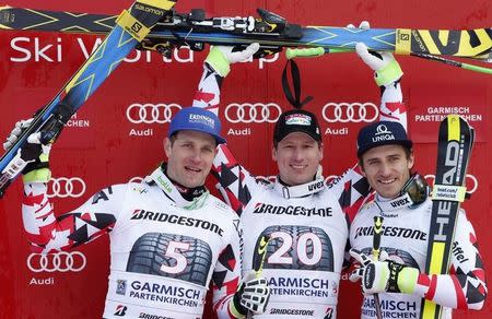 Austria's Romed Baumann, Hannes Reichelt and Matthias Mayer (L-R) celebrate their victory on the podium after the men's Alpine Skiing World Cup downhill race in Garmisch-Partenkirchen February 28, 2015. REUTERS/Michaela Rehle