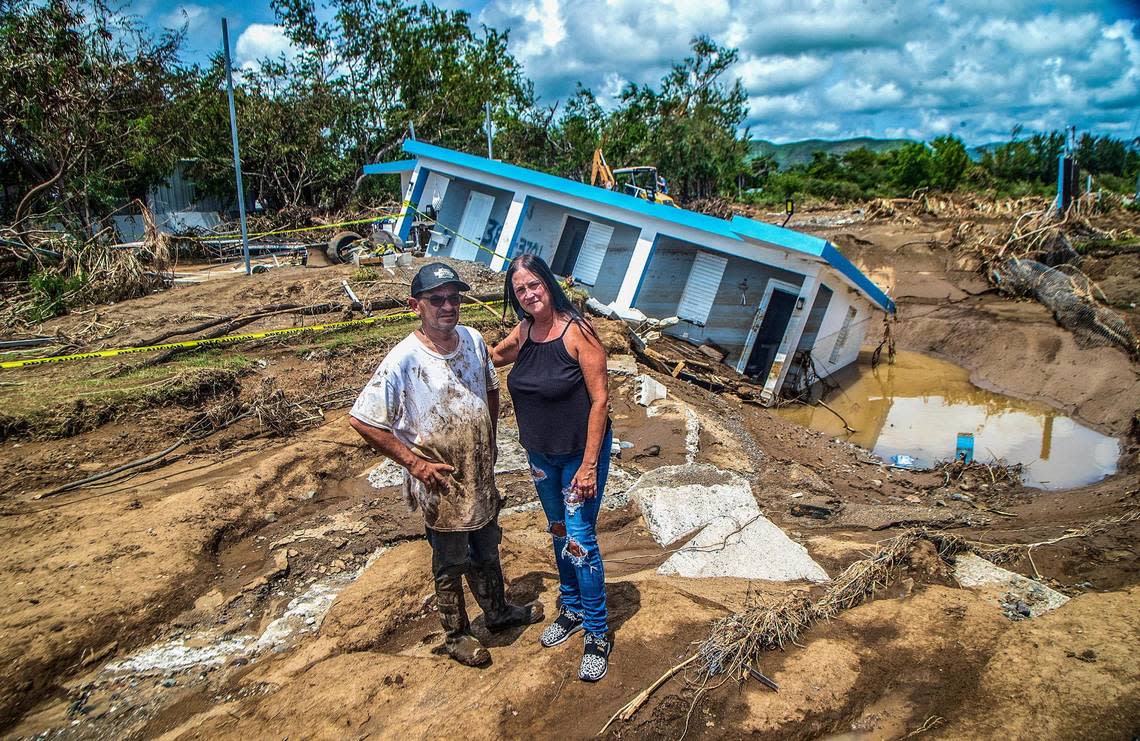 Leida Rodriguez and Javier Castellanos stand in front of their house that collapsed into a sink hole after been flooded with water and mud from the Nigua river during Hurricane Fiona at Villa Esperanza in Salinas, Puerto Rico,, on Friday September 23, 2022