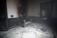 A couch and art work destroyed by fire are seen inside the Congress building after protesters set a part of the building on fire, in Guatemala City, Saturday, Nov. 21, 2020. Hundreds of protesters were protesting in various parts of the country Saturday against Guatemalan President Alejandro Giammattei and members of Congress for the approval of the 2021 budget that reduced funds for education, health and the fight for human rights. (AP Photo/Moises Castillo)