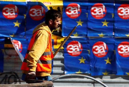 A man passes next to posters reading "yes" for the referendum in Macedonia on changing the country's name that would open the way for it to join NATO and the European Union, in Skopje, Macedonia September 26 2018. REUTETS/Ognen Teofilovski