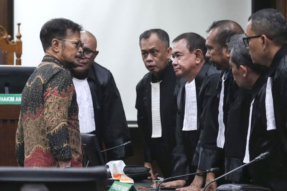 Former Indonesian Agriculture Minister Syahrul Yasin Limpo, left, consults with his defense team after his sentencing at the Corruption Court in Jakarta, Indonesia Thursday, July 11, 2024. Indonesia's anti-graft court sentenced Limpo to 10 years in prison Thursday after finding him guilty of corruption-related extortion, abuse of power and bribery involving ministry contracts with private vendors. (AP Photo/Tatan Syuflana)