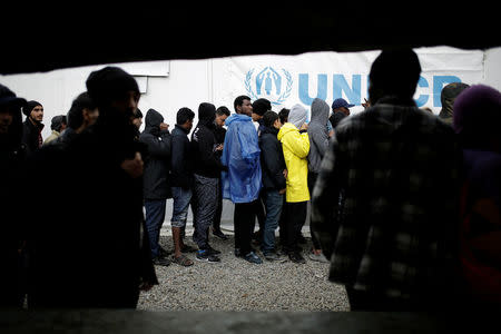 Refugees and migrants line up to receive their lunch provided by the Greek authorities, at a makeshift camp next to the Moria camp on the island of Lesbos, Greece, November 30, 2017. REUTERS/Alkis Konstantinidis