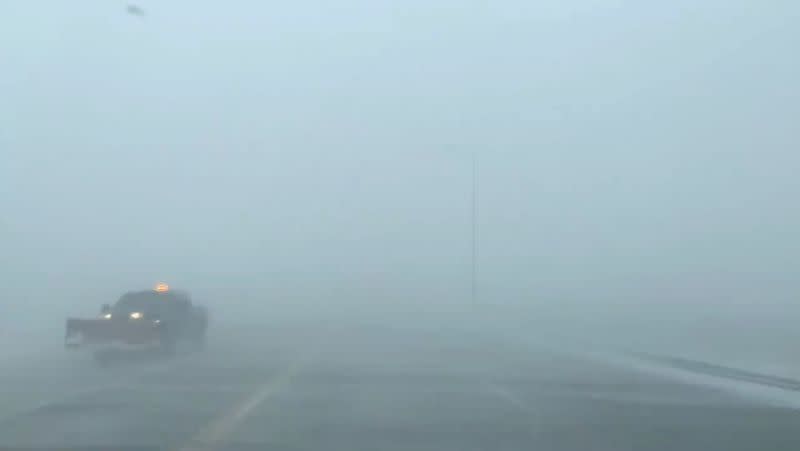 A snow plow vehicle drives during a blizzard along a road in Sioux Falls, South Dakota, U.S. in this still frame obtained from social media video