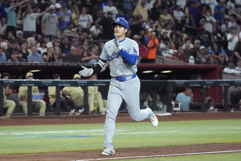 Los Angeles Dodgers designated hitter Shohei Ohtani, of Japan, claps has he rounds the bases after hitting a home run against the Arizona Diamondbacks during the eighth inning of a baseball game Friday, Aug. 30, 2024, in Phoenix. (AP Photo/Ross D. Franklin)