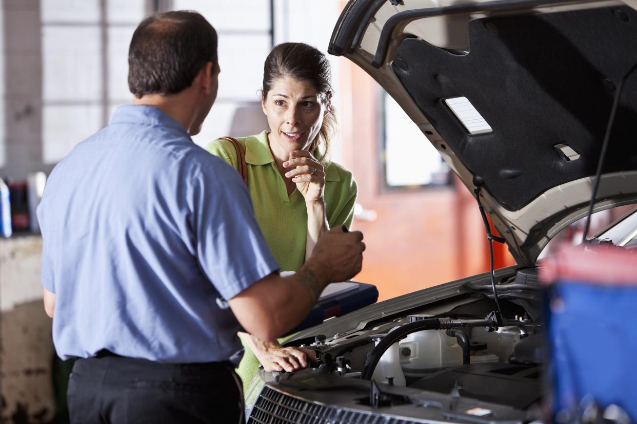auto mechanic talking with worried customer