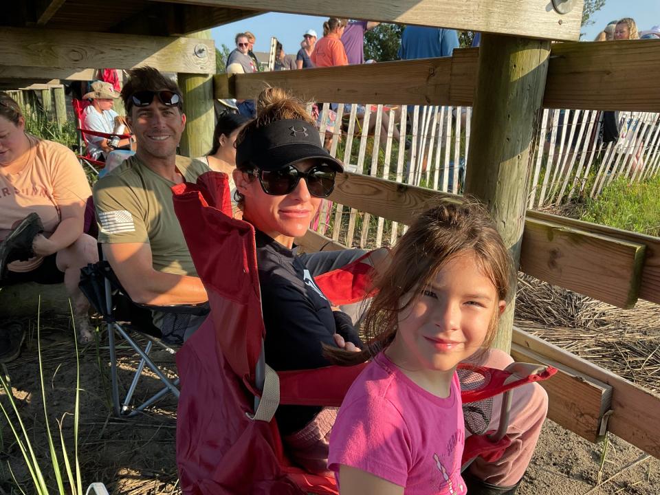 Ben, left, Taylor, and Bryce, 8-years-old, Blumenthal relax under the docks Wednesday, July 26, 2023, as they wait for the Chincoteague Pony Swim to begin. The family drove up from Atlanta on Sunday and arrived in time for carnival at their first pony penning. They plan to take part in the auction to try to buy a pony.