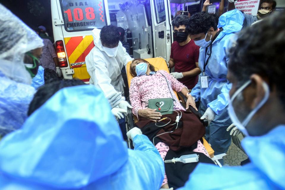 Health workers transfer an inured passenger on a stretcher to take her inside a hospital in Kozhikode, Kerela, after an Air India Express jet crashed by overshooting the runway at Calicut International Airport, on August 7, 2020. - At least 19 people died when a passenger jet skidded off the runway after landing in heavy rain in India, police said on August 7. (Photo by - / AFP) (Photo by -/AFP via Getty Images)