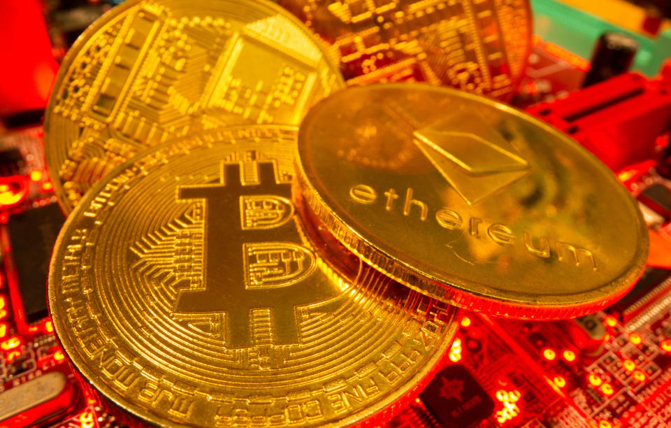 Representations of the virtual currency Bitcoin and Ethereum stand on a motherboard in this picture illustration taken May 20, 2021. REUTERS/Dado Ruvic/Illustration