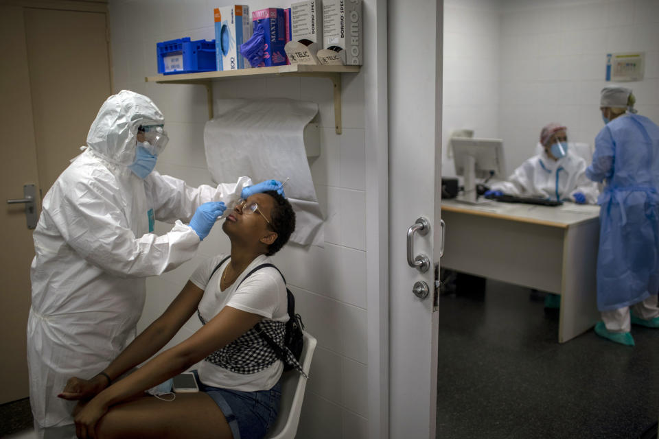 ARCHIVO - En esta imagen del martes 14 de julio de 2020, personal sanitario toma una muestra para una prueba PCR de COVID-19 en un hospital de Hospitalet, a las afueras de Barcelona, España. Las autoridades sanitarias en la región nororiental de Cataluña han admitido que sus preparativos para gestionar el repunte de casos con la vuelta a la normalidad han demostrado ser insuficientes. (AP Foto/Emilio Morenatti, File)