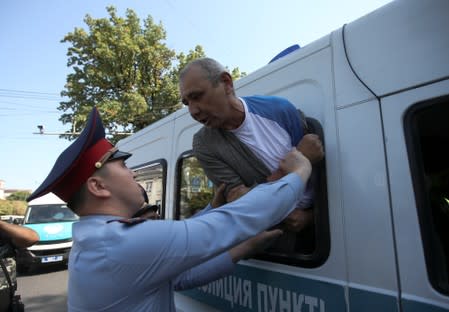 A law enforcement officer detains a man during an anti-government protest in Almaty