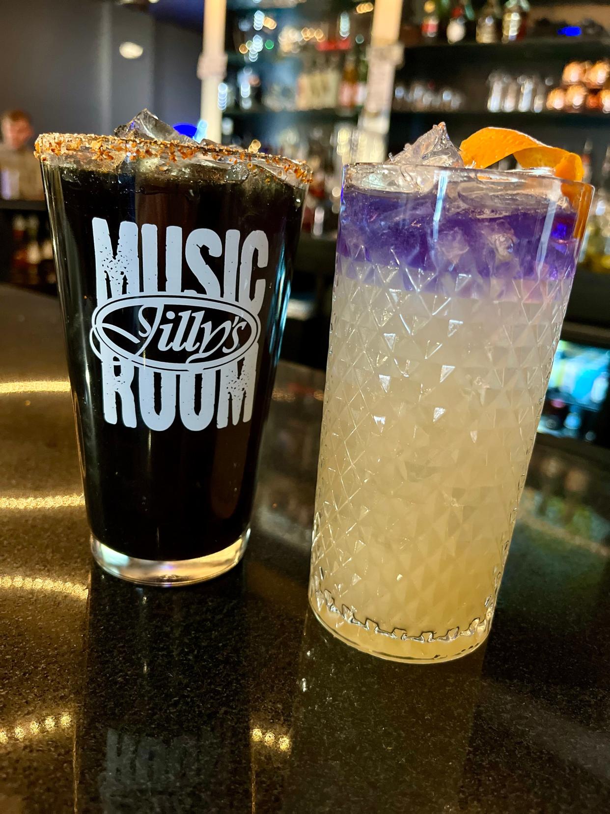 Jilly's eclipse-themed drinks are The Penumbra mocktail (left) with lemonade, blueberry muddle, edible glitter, black food coloring and Tajin rim. The Path of Totality cocktail (right) has pear nectar, St. Germaine Empress gin float and an orange peel twist garnish.