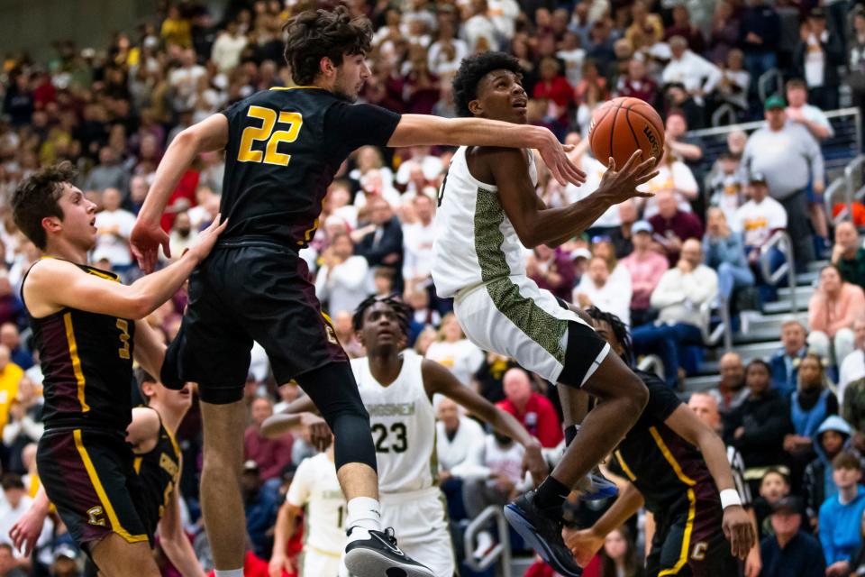 Penn's Markus Burton (3) drives past Chesterton's George Vrahoretis (22) during the Penn vs. Chesterton regional championship game Saturday, March 11, 2023 at Michigan City High School.