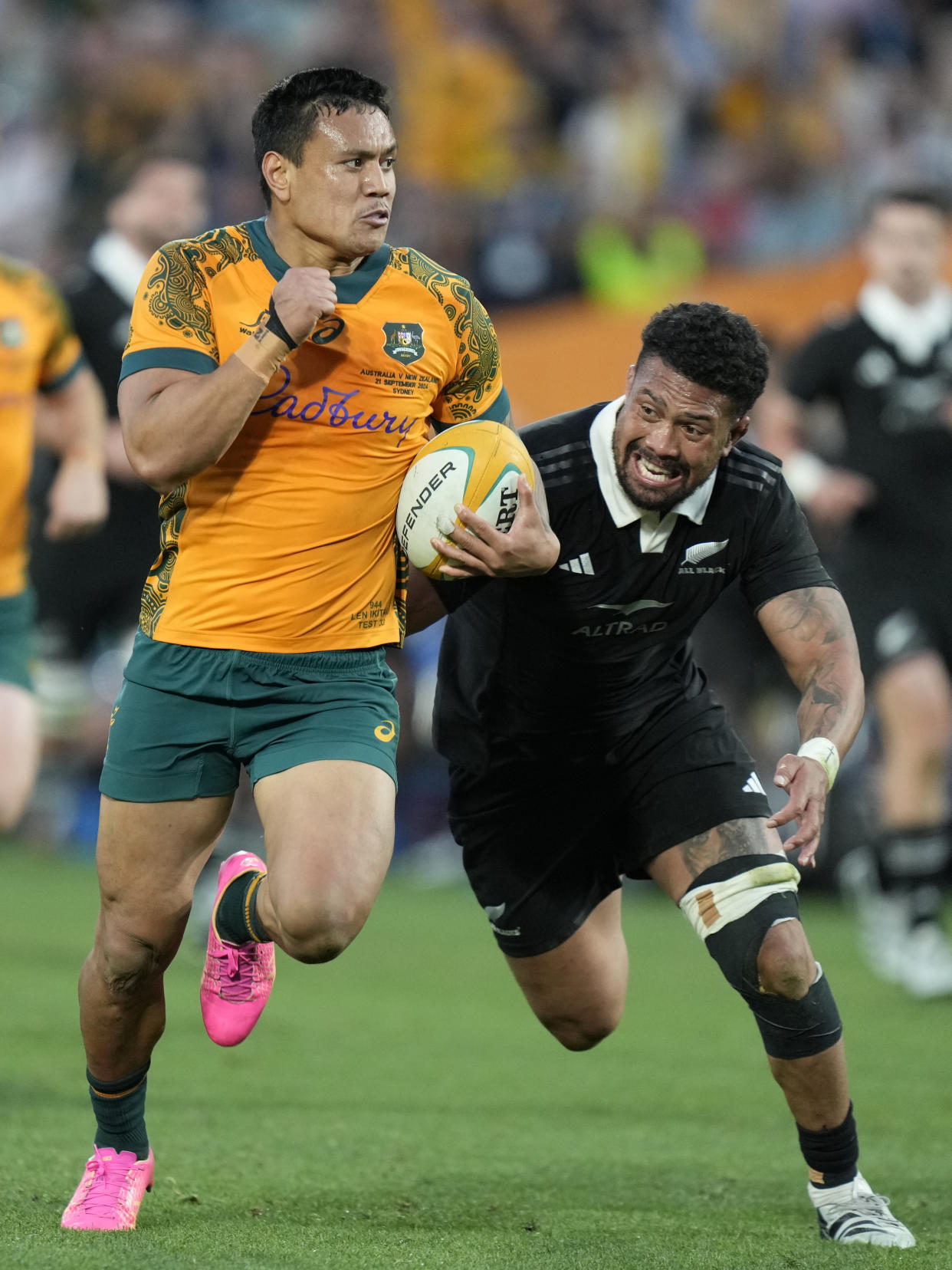 Australia's Len Ikiau, left, races away from New Zealand's Ardie Savea during their rugby union test match in Sydney, Saturday, Sept. 21, 2024. (AP Photo/Rick Rycroft)