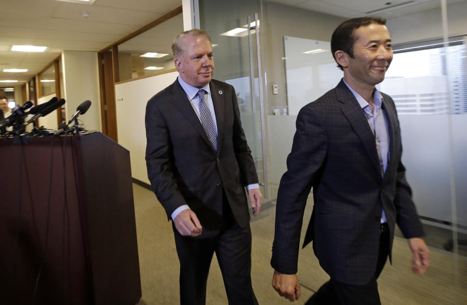 Seattle Mayor Ed Murray, left, walks away with his husband, Michael Shiosaki, after reading a statement to the media, Friday, April 7, 2017, in Seattle. A lawsuit filed Thursday accuses Murray of sexually molesting a teenage high-school dropout in the 1980s, and in interviews with The Seattle Times, two other men claim he abused them. The mayor denied the allegations through his personal spokesman Jeff Reading. (AP Photo/Elaine Thompson)