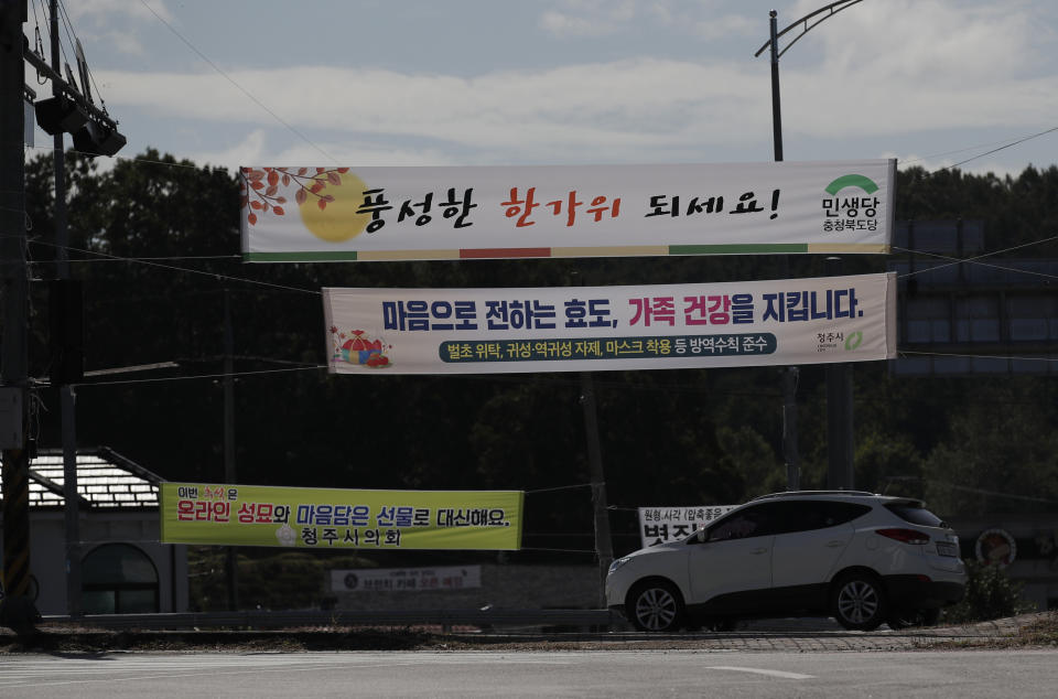 Banners reading “Let’s mark this Chuseok with online pilgrimages to ancestral graves and the sending of heartfelt gifts,“ bottom, and “Refrain yourself from visiting hometown. Wearing masks. Secure your family’s health.” and “Showing your filial piety by heart will guard the health of your family.” are seen on the street in Cheongju, South Korea, Friday, Sept. 25, 2020. The coronavirus is forcing South Koreans to celebrate their Thanksgiving holiday differently this year. Health authorities are discouraging travel during the five-day Chuseok autumn holidays that begin Wednesday, Sept. 30, 2020 because of concern that people could spread the virus. (AP Photo/Lee Jin-man)