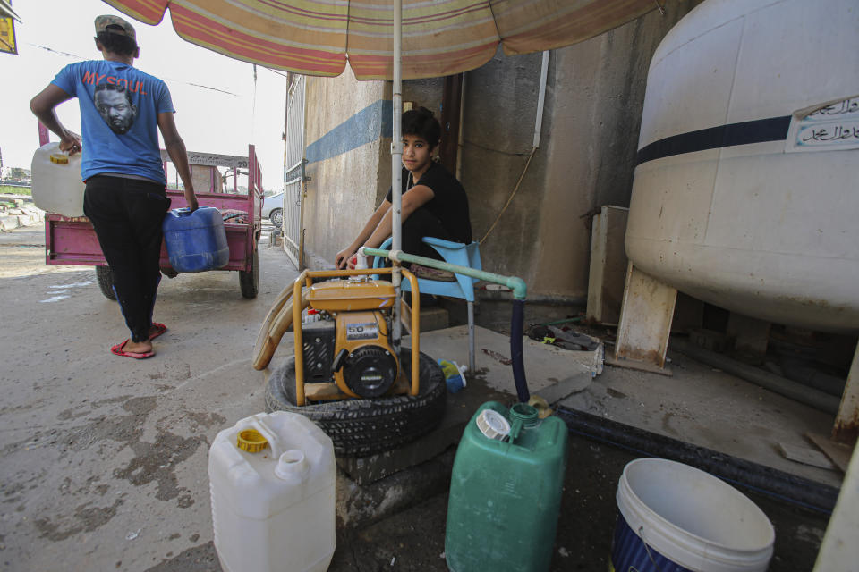 A street vendor who sells drinking water waits for customers in Basra, Iraq on July 13, 2020. Iraq's Minister of Water Resources is sounding the alarm over looming water shortages if agreements are not forged with neighboring Turkey for its irrigation and dam projects, which he said has decreased river inflows to Iraq's parched plains. (AP Photo/Nabil al-Jurani)