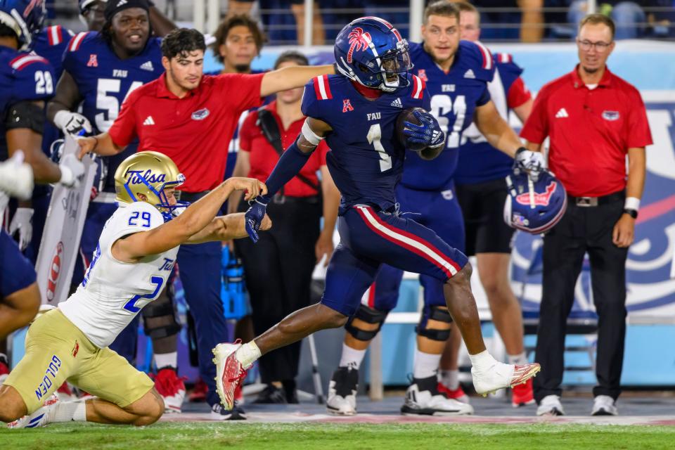 FAU wide receiver LaJohntay Wester (1) runs with the ball past Tulsa punter Angus Davies (29) during an NCAA football game on Saturday, Oct. 7, 2023 in Boca Raton, Fla. (AP Photo/Doug Murray)