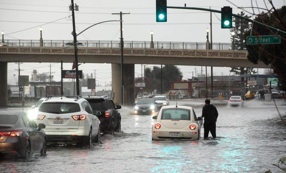 A motorist is stranded by flooding on 9th Street in Modesto, Calif., Saturday, Dec. 10, 2022.