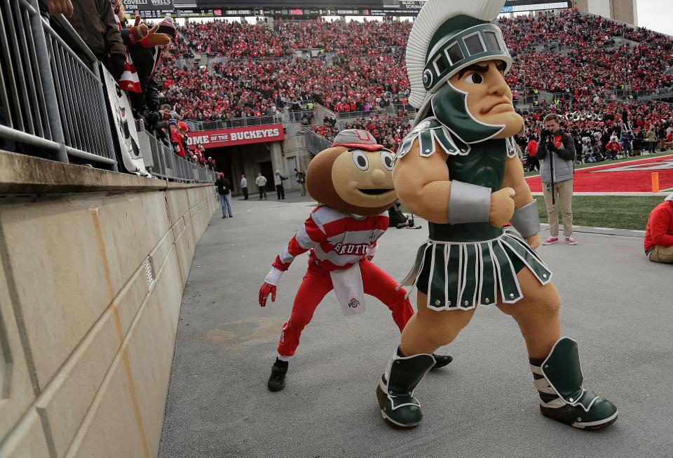 Ohio State's Brutus Buckeye sneaks up on Michigan State mascot Sparty.