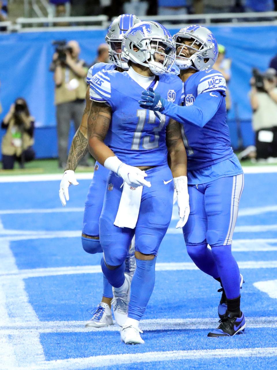 Marvin Jones Jr. (0) and Kalif Raymond (11) celebrate with Detroit Lions running back Craig Reynolds after his touchdown during second-half action at Ford Field in Detroit on Sunday, Oct, 8, 2023.