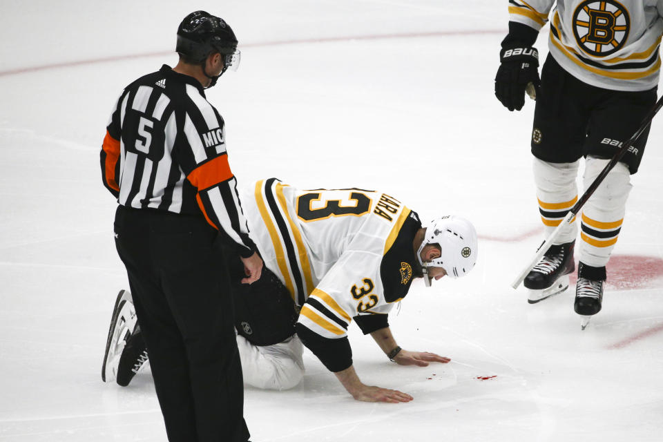 Boston Bruins defenseman Zdeno Chara, of Slovakia, kneels on the ice after being hit in the face by the puck during the second period of Game 4 of the NHL hockey Stanley Cup Final against the St. Louis Blues Monday, June 3, 2019, in St. Louis. (AP Photo/Scott Kane)