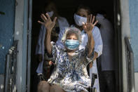 Zelia de Carvalho Morley, 106, waves before receiving a shot of China's Sinovac CoronaVac vaccine for the new coronavirus at the retirement home where she lives in Rio de Janeiro, Brazil, Wednesday, Jan. 20, 2021. De Carvalho Morley lived through the 1918 flu pandemic. (AP Photo/Bruna Prado)