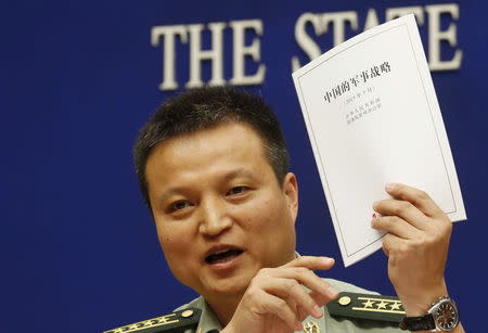 Spokesperson of Chinese Ministry of National Defense Senior Colonel Yang Yujun holds a copy of the annual white paper on China's military strategy during a news conference in Beijing, China, May 26, 2015. REUTERS/Kim Kyung-Hoon