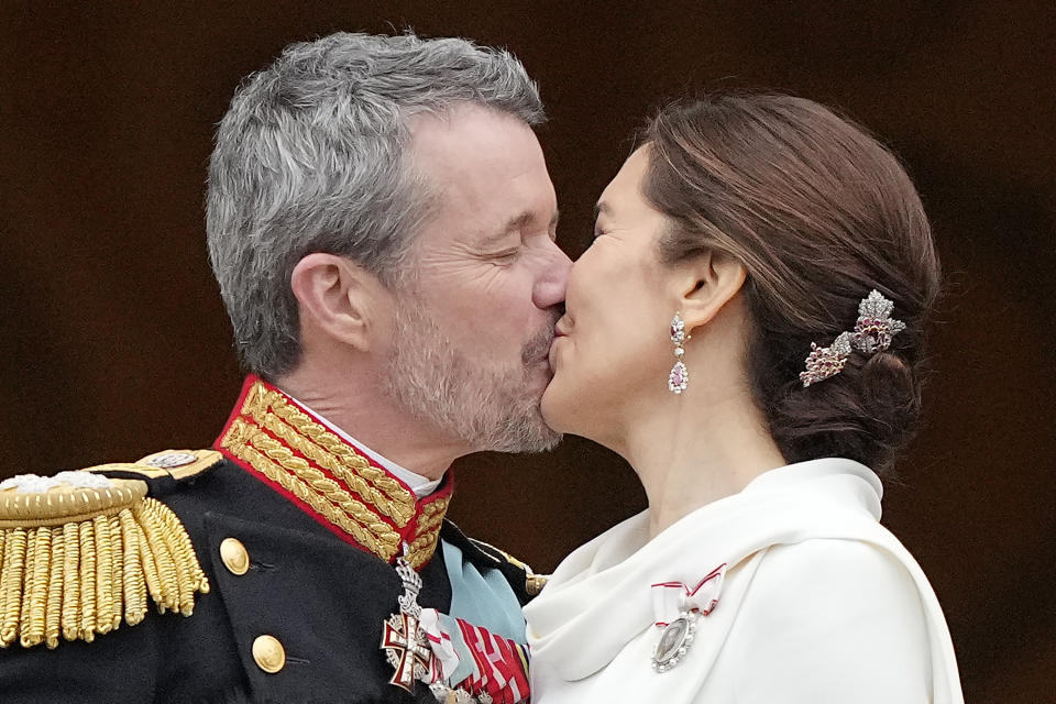 Denmark's King Frederik X kisses his wife Denmark's Queen Mary on the balcony of Christiansborg Palace in Copenhagen, Denmark, Sunday, Jan. 14, 2024. Queen Margrethe II has become Denmark's first monarch to abdicate in nearly 900 years when she handed over the throne to her son, who has become King Frederik X. (AP Photo/Martin Meissner)