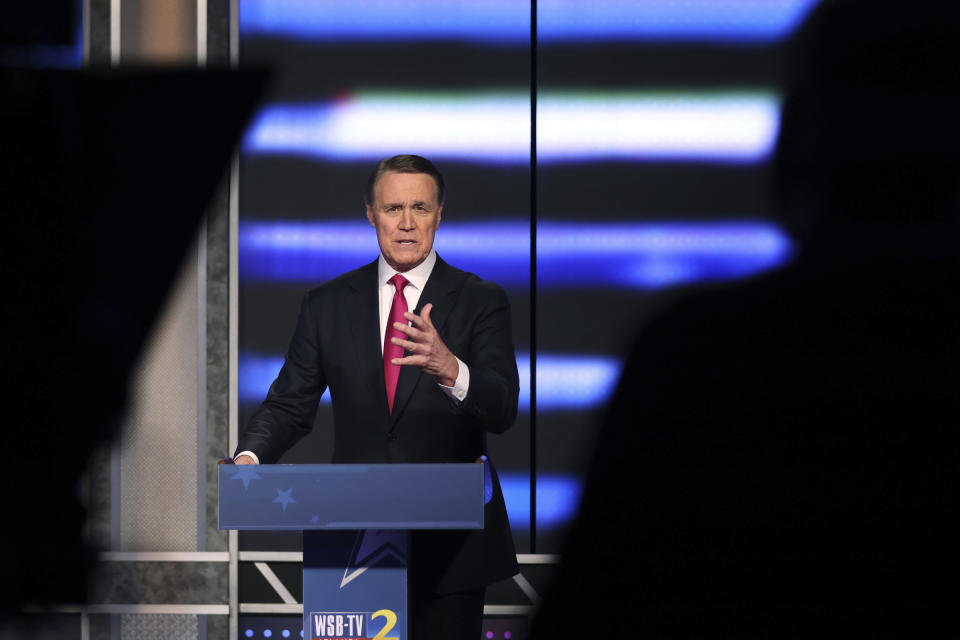 Former Sen. David Perdue at the podium in a TV studio.