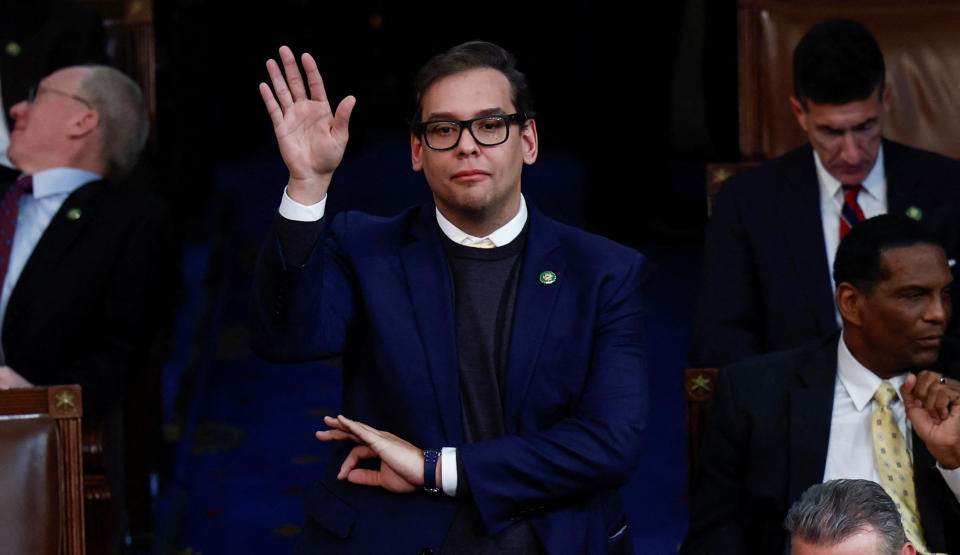 Rep. George Santos, R-N.Y., raises his right hand as he casts his vote, while touching his left thumb to his index finger.