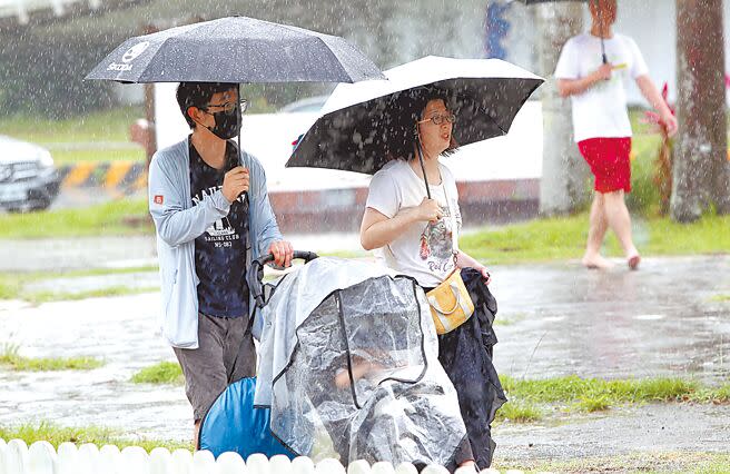 台灣北部4日午間下起短暫陣雨，在北市河濱公園野餐的民眾紛紛撐起雨傘遮擋雨勢。（鄭任南攝）