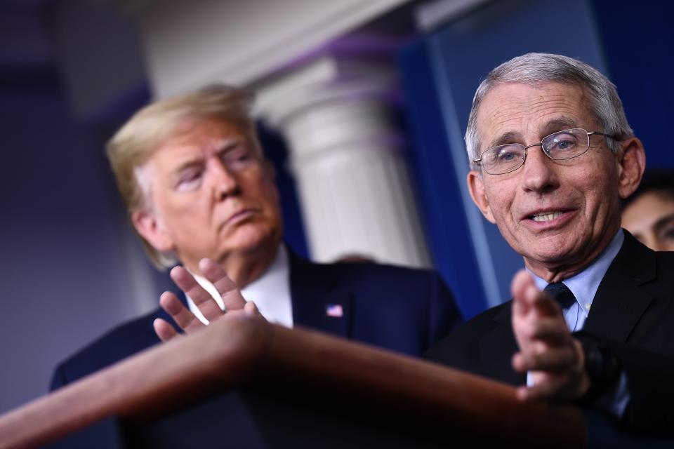 Dr. Anthony Fauci speaks as US President Donald Trump listens during the daily press briefing on the Coronavirus pandemic situation at the White House on March 17, 2020 in Washington, DC. - The coronavirus outbreak has transformed the US virtually overnight from a place of boundless consumerism to one suddenly constrained by nesting and social distancing.The crisis tests all retailers, leading to temporary store closures at companies like Apple and Nike, manic buying of food staples at supermarkets and big-box stores like Walmart even as many stores remain open for business -- albeit in a weirdly anemic consumer environment. (Photo by Brendan Smialowski / AFP) (Photo by BRENDAN SMIALOWSKI/AFP via Getty Images)