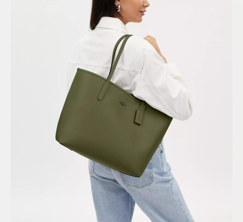 someone holding the City Tote Bag from Coach Outlet on their shoulder