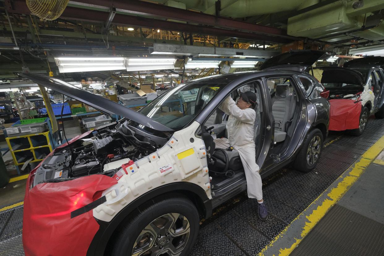 A worker installs interior components into a Honda CR-V on the assembly line at the Honda manufacturing plant in Marysville in 2018. The company is recalling 500,000 vehicles with a potential seat belt problem.