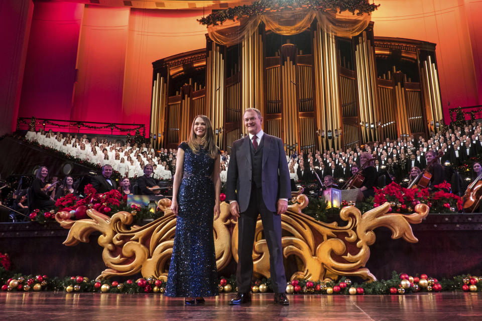 This image released by PBS shows actors Sutton Foster, foreground left, and Hugh Bonneville, in "Christmas with the Mormon Tabernacle Choir Featuring Sutton Foster and Hugh Bonneville," airing Monday, Dec. 17 on PBS. (Justin Hackworth/PBS via AP)