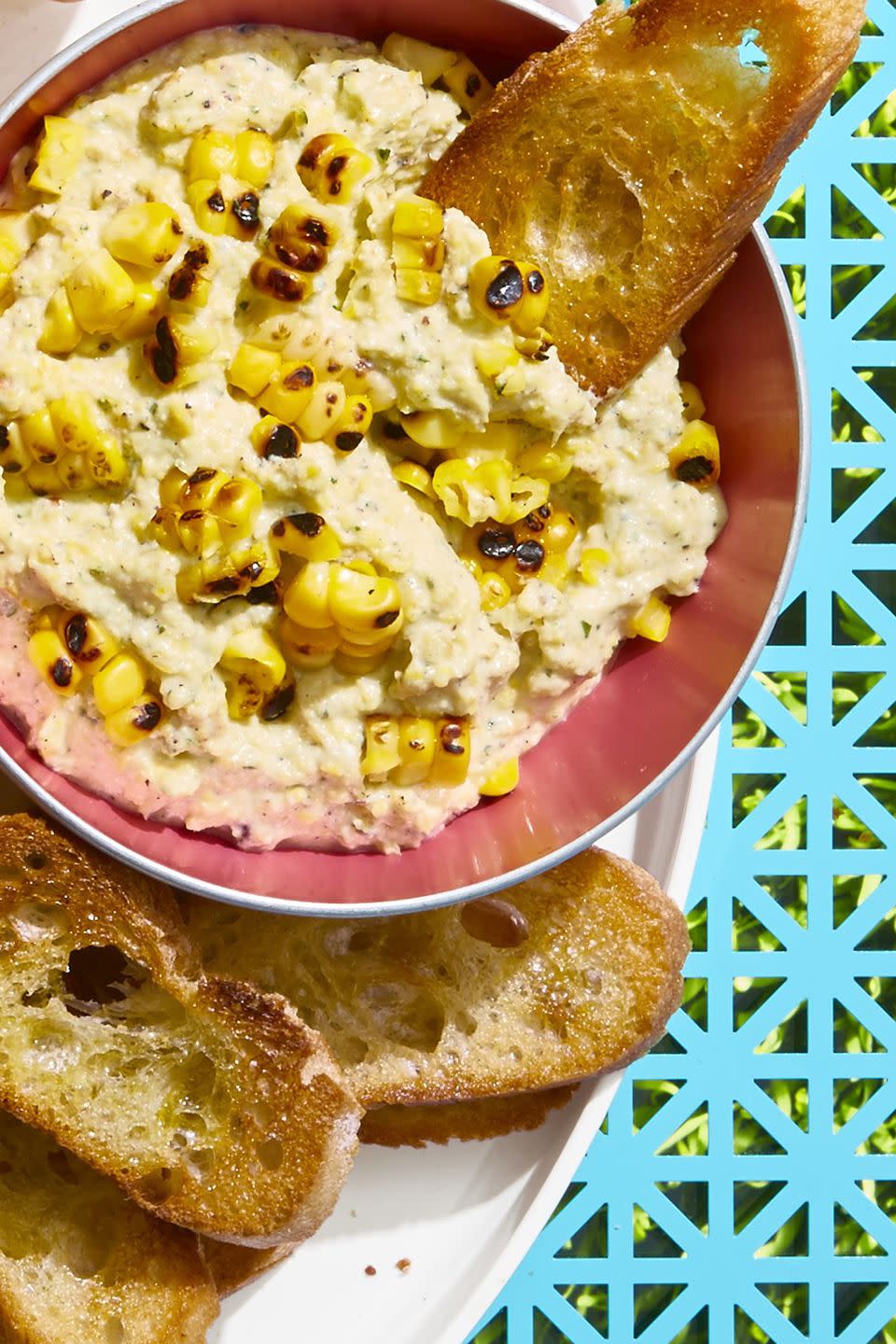 <p>You're going to want to dunk everything into this super cheesy dip, but we strongly recommend toasted baguette slices.</p><p>Get the <a href="https://www.goodhousekeeping.com/food-recipes/party-ideas/a21605075/grilled-corn-and-ricotta-dip/" rel="nofollow noopener" target="_blank" data-ylk="slk:Grilled Corn and Ricotta Dip recipe;elm:context_link;itc:0;sec:content-canvas" class="link "><strong>Grilled Corn and Ricotta Dip recipe</strong></a>. </p>