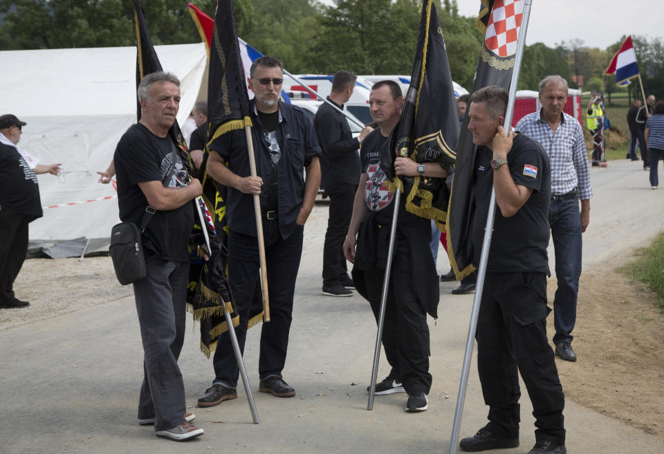 FILE - In this Saturday, May 12, 2018 file photo, Croatian war veterans hold their wartime unit's flags which they were prevented to bring to a commemoration ceremony, in Bleiburg, Austria. Thousands will gather in a field in southern Austria on Saturday, May 18, 2018, for an annual event to commemorate the massacre of tens of thousands mostly pro-Nazi soldiers known as Ustashas who fled to the village of Bleiburg in May 1945 amid a Yugoslav army offensive, only to be turned back by the British military and into the hands of revengeful antifascists. (AP Photo/Darko Bandic, File)