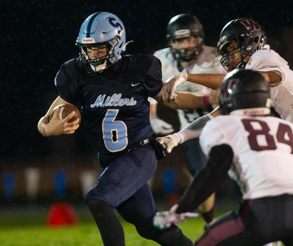 Springfield quarterback Zack Sherman, left, runs the ball against Willamette during the first half of the game in Springfield on Friday, Oct. 13, 2023.